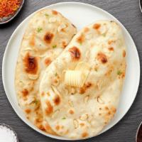 Garlic Naan · Freshly baked bread in a clay oven garnished with garlic and butter.