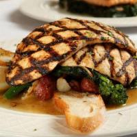 Grilled Marinated Chicken Breast · Served over a bed of broccoli rabe and roasted potatoes.