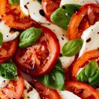 Mozzarella Caprese · Homemade fresh mozzarella cheese, tomatoes, roasted peppers, and fresh basil drizzled with e...