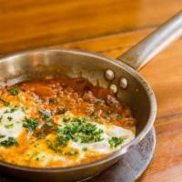 Seni'Ya Shakshuka · Shakshuka with ground beef stew and two eggs over easy.