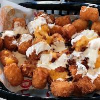 Loaded Tater Tots · Topped with queso, crema, & bacon bits.