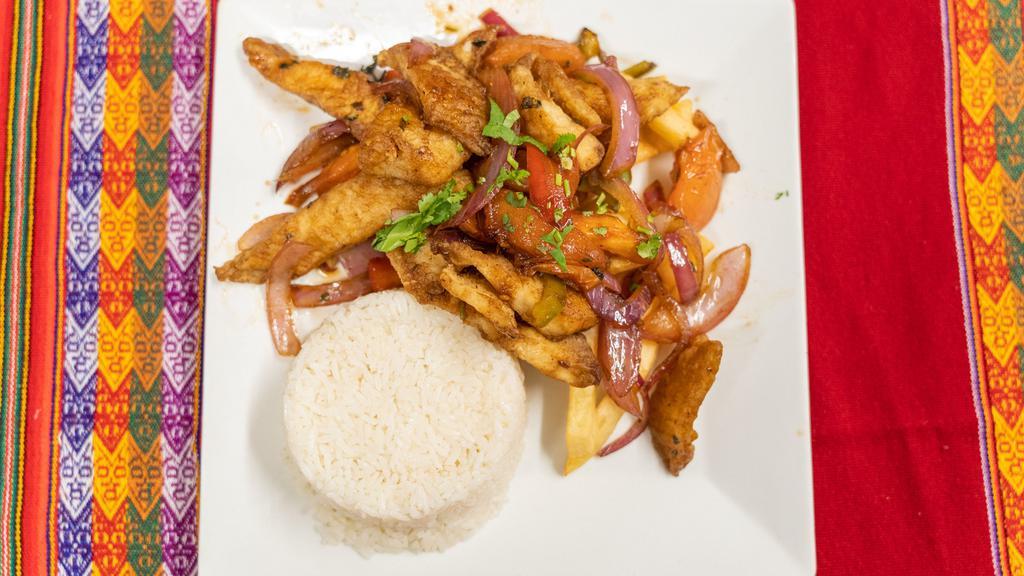 Pollo Saltado · Fried sliced chicken with onion, tomato, rice, and French fries.