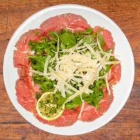 Beef Carpaccio · Gluten-Free. Thinly sliced raw beef, olive oil, lemon, capers, Parmesan and arugula.