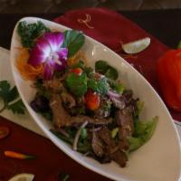 Nam Tok Nua (Beef Salad) · Spicy. Grilled marinated beef with red onion, scallions, mints, and roasted minced rice.