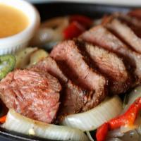 Filet Mignon Fajitas For One · Tender cuts of grain-fed Midwest filet mignon on a bed of sauteed peppers and onions with ou...
