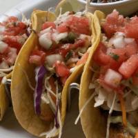 Grilled Fish Tacos · Choose between two or three corn tortillas stuffed with grilled tilapia, shredded cabbage, p...