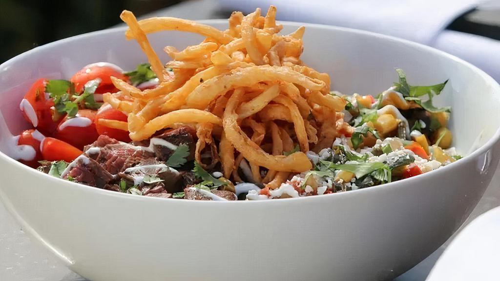 Steak Fajita Bowl · Mesquite grilled skirt steak with rice, roasted corn, black beans, sautéed peppers, onions, chipotle crema, grape tomatoes, queso fresco, topped with crispy tortilla strips.
