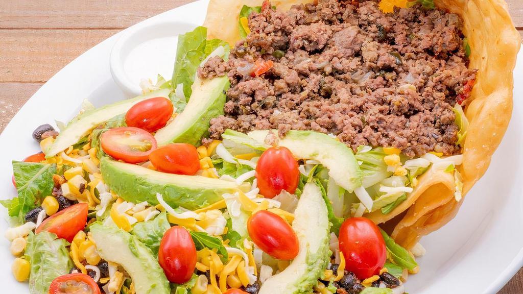 Classic Taco Salad · Choose from: ground beef, pulled or fajita chicken on a bed of fresh romaine lettuce. Topped with avocados, grape tomatoes, black beans, roasted corn, cheddar and Monterey Jack cheese in our homemade tortilla shell with homemade ranch on the side