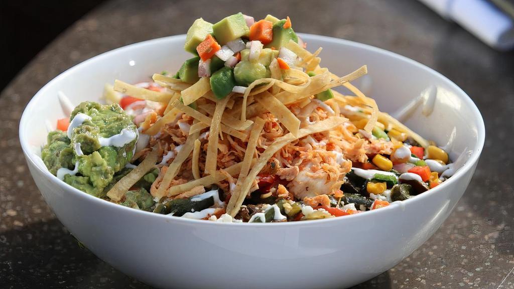 Chicken Tortilla Bowl · Sautéed pulled chicken, rice, roasted corn, black beans, sautéed peppers, onions and queso fresco, topped with crispy tortilla strips, and pickled avocado escabeche.
