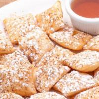 Sopapillas · Puffed Mexican pastries dusted with cinnamon and powdered sugar and served with a side of ho...