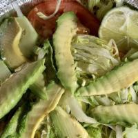 Ensalada De Aguacate · Avocado salad with lettuce, tomato and onions.