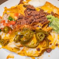 Nachos · Tortilla chips topped with fried beans, melted cheese, pico de gallo, guacamole, sour cream ...