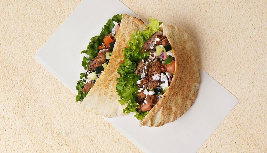Beef & Lamb Shawarma Pita Sandwich · Wrapped in a pita with cucumber, tomato, and your choice of sauce.
