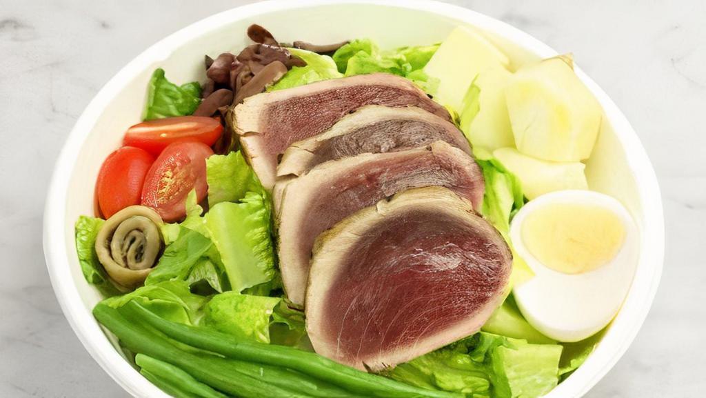 Seared Tuna Niçoise · Romaine, haricots verts, potatoes, anchovies, black olives, and hard-boiled egg with lemon dressing.