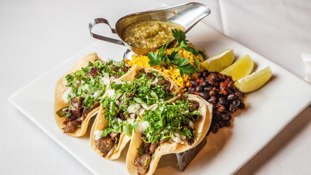 Steak Tacos · Three stuffed soft corn tortillas served with yellow rice ,black beans and spicy sauce