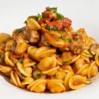 Orechietti Alla Barese · Hat-shaped pasta with sausage, peas, mushrooms, and sun-dried tomatoes.