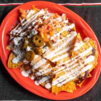 Nachos Grande · Homemade chips smothered with black beans, melted cheese, sour cream, pico de gallo and jala...