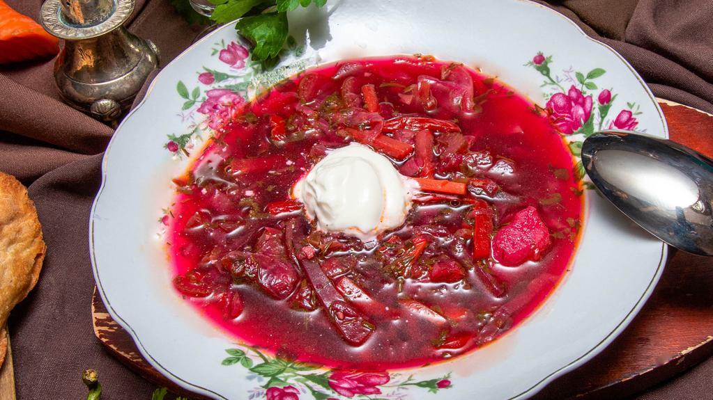 Borscht · Flavorful beet, cabbage, carrot and fresh herb soup served with sour cream and Georgian bread.
