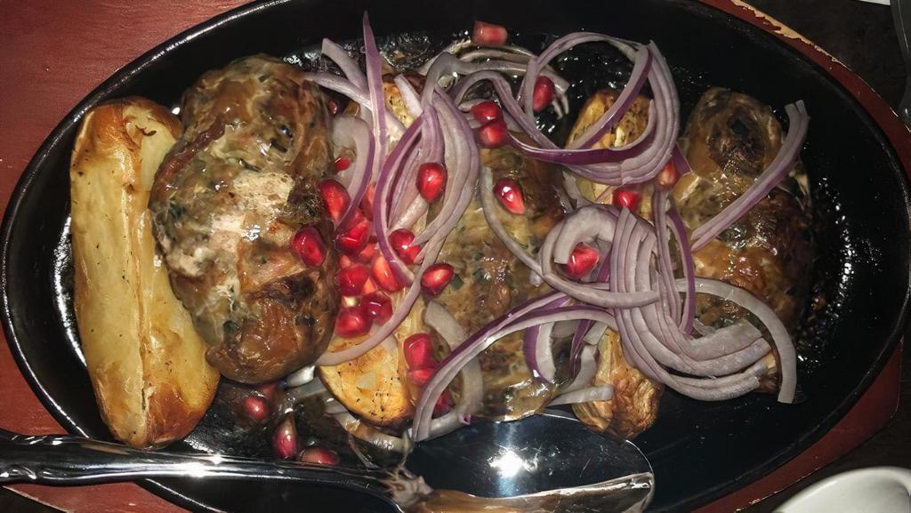 Abkhazura · Organic grass-fed ground lamb or beef and pork with herbs and pomegranate seeds, served with baked potatoes and tkemali sauce.