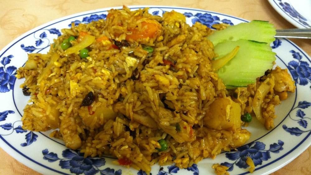 Pineapple Fried Rice · Cooked with shrimp, chicken, imitation crab, pineapple, tomato, raisins, and cashews.