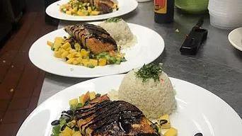 Salmon El Refin · Served with mango, black beans and avocado salsa.