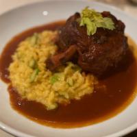 Pork Osso Buco · Fork tender and slow-roasted pork shank over risotto Milanese.