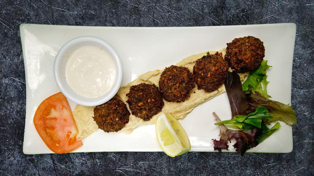 Falafel Plate · Deep fried chick peas and vegetables blended with spices served with hummus and tahini sauce on top.