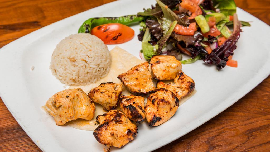 Chicken Shish Kebab · Marinated grilled chicken served with rice and mixed green salad.