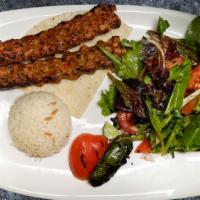 Chicken Adana · Hand-minced chicken kebab mounted on a wide iron skewer. Served with rice and mixed green sa...