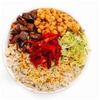 D · A base of brown rice holds warm roasted purple eggplant, arugula, and flavor-packed sun drie...