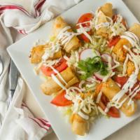 Tacos Dorados · Fried chicken tacos topped with sour cream, lettuce, onions, and queso fresco.