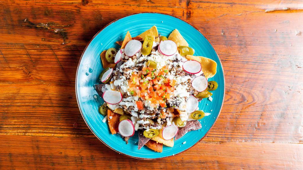 Nachos  · With bechamel cheese sauce, pico de gallo, crema, beans (black or pinto), jalapeño and salsa ranchera. Choice of: plain, ground beef, al pastor, chicken (lime or adobo), quinoa - for an additional charge, carne asada