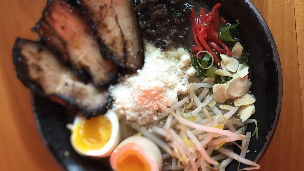 Cheese Chashu Tonkotsu · Pork broth, thin noodles, sliced pork belly, parmesan cheese, scallions, bean sprouts, kikurage mushrooms, shredded red ginger, fried garlic, sesame seeds and black fried garlic oil (spicy - half a soft boiled egg, spicy paste & oil).
