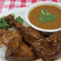 Pollo Guisado · Stewed Chicken
with tostones, rice and beans or moro