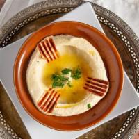 Hummus · Vegan. A puree of chickpeas, blended with tahini, garlic and fresh lemon juice. Topped with ...