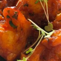 Lasuni Gobi · Contains gluten. From the Himalayan rim. Mini cauliflower tossed with tomato, garlic and cil...