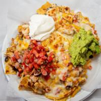 Nachos · Nachos covered in black beans, melted cheese, topped with sour cream, pico de gallo and guac...