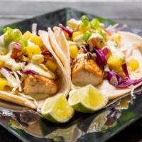 Mahi Mahi Tacos · Two pan seared mahi tacos. Cabbage, pineapple-mango salsa, avocado ranch, lime, and green on...