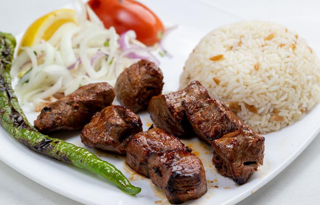 Lamb Shish Kebab · Skewered lamb (8 cubes) charcoal broiled tender cubes of lamb marinated with our chef's seasoning. It is served with rice and grilled vegetables.