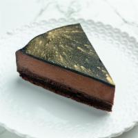 Tarta De Chocoloate · Slice of sacher cake made with hazelnut praline, chocolate cremoso, and a chocolate glaze.