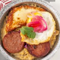 Mangu Con Los Tres Golpe · Mash Plantains with butter, Onion on top, Fried Egg, Salami and Fried Cheese.