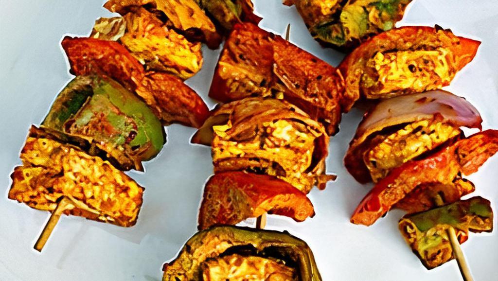 Paneer Tikka  · Paneer(cottage cheese), Onions and Green Pepper marinated with yogurt, herbs and spices and grilled in a clay oven.
