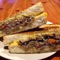 Grilled Rib Eye Cheese Steak · Prime rib eye steak, grilled peppers & onions melted into American cheese on a garlic romano...