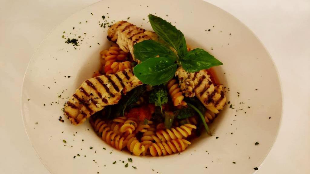 Fusilli Pollo E Rapini · Corkscrew pasta with chicken, broccoli rabe, garlic and tomato sauce.