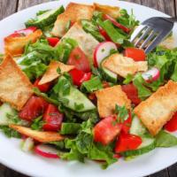 The Fattoush Salad · A house favorite! Crisp romaine hearts with fresh tomatoes, cucumbers, tossed with tangy Leb...