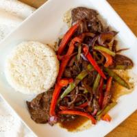 Bistec Encebollado Dominicano · Steak, onions, red pepper sautéed served with one choice of sweet plantains, tostones, madur...