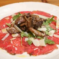 Carpaccio Di Manzo · Thinly sliced beef tenderloin, mushrooms, arugula, and Parmesan cheese.
