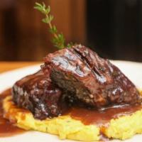 Costine Di Bue · Braised beef short ribs served with soft polenta.