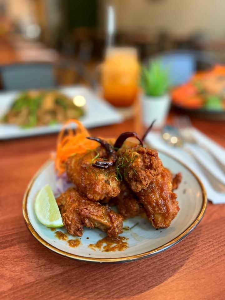 A-7 Tom Yum Wings · Deep fried breaded chicken wings coated with sweet and spicy Tom Yum flavored sauce served with lime.  **If you need plastic utensils, please request.**