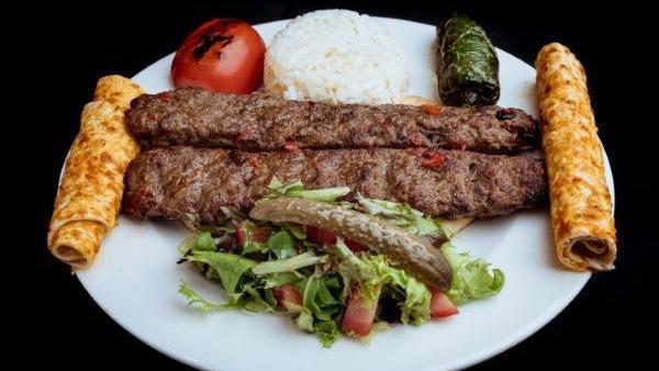 Lamb Adana Kebab · Ground lamb flavored with red bell peppers, slightly seasoned with paprika and grilled on skewers served with rice and house salad.